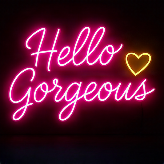 Hello Gorgeous magnet with glowing neon pink script typography and gold heart accent on deep dark background